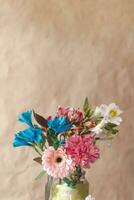 A glass jar full with colorful spring flowers photo