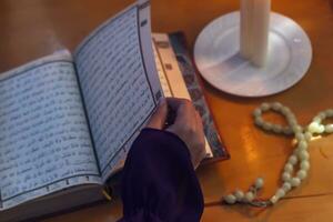 Praying young muslim woman. Middle eastern girl praying and reading the holy Quran. Muslim woman studying The Quran photo