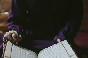 Praying young muslim woman. Middle eastern girl praying and reading the holy Quran. Muslim woman studying The Quran photo