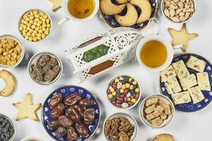 Iftar foods on white table. Traditional middle-eastern lunch with cookies and sweets photo