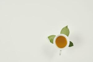 un taza de té y hojas en blanco foto