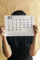 A woman holding simple July 2019 calendar photo