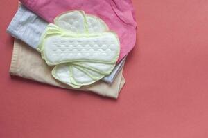 Women's panties and sanitary pads on a red background photo