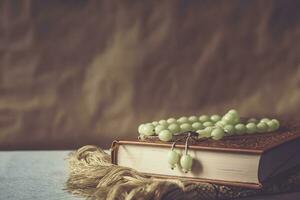 The Holy Quran with rosary and praying carpet. Image of The Holy Quran with rosary. Muslim Rosary Beads And Quran photo