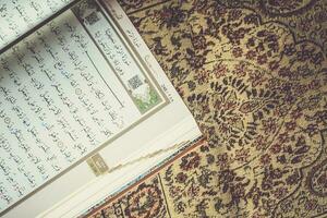 The Holy Quran on praying carpet. Flat lay view photo