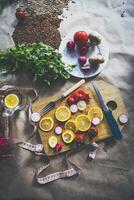 Healthy vegan food background with cutting board and lemon slices. Top view to organic food background with cutting board and lemon slices photo