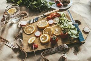 Healthy vegan food background with cutting board and lemon slices. Top view to organic food background with cutting board and lemon slices photo