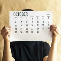 A woman holding simple October 2019 calendar photo