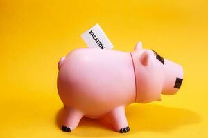 piggy bank and text vacation on paper photo