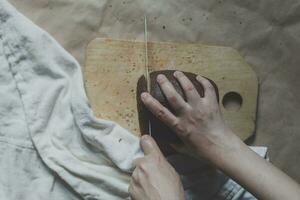 Housewife cutting a bread. Female cut bread on cutting board. View from above. Top view of breads photo