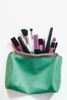 Women's make-up bag with beauty products. Cosmetics and brushes on white background, View from above. Beauty concept photo