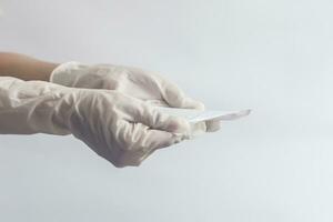 Female's hygiene products. Woman's hands in medical gloves holding sanitary napkins against white background. Period days concept showing feminine menstrual cycle. photo