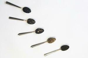 Variety of dry tea in spoons on the white. An assortment of dry tea. Different herbal wellness dried teas. Dry tea leaves on white. Copy space photo