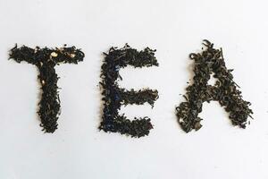 The word tea made with dry tea leafs photo