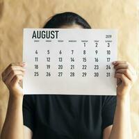 A woman holding simple August 2019 calendar photo