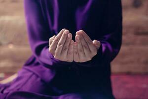 Praying young muslim woman. Middle eastern girl praying and reading the holy Quran. Muslim woman studying The Quran photo