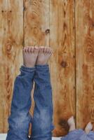 Two young brothers lying on their bed. Kids having fun. Two little brothers raising their legs against the wooden desk. photo