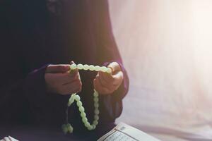 Praying young muslim woman. Middle eastern girl praying and reading the holy Quran. Muslim woman studying The Quran photo