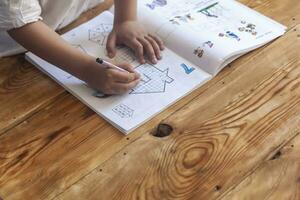 Preschool age child doing the math. Little boy doing homework. Drawing on kid notepad. Free space photo