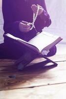 Praying young muslim woman. Middle eastern girl praying and reading the holy Quran. Muslim woman studying The Quran photo