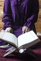 Praying young muslim woman. Middle eastern girl praying and reading the holy Quran. Muslim woman studying The Quran photo