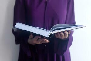 Praying young muslim woman. Middle eastern girl praying and reading the holy Quran. Muslim woman studying The Quran photo