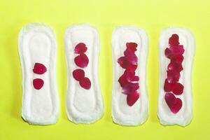 Female's hygiene products on yellow background. Concept of critical days, menstrual cycle, period days, PMS photo