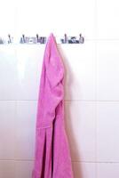 Female's pink bathrobe hanging on hook photo