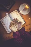 Praying young muslim woman. Middle eastern girl praying and reading the holy Quran. Muslim woman studying The Quran photo