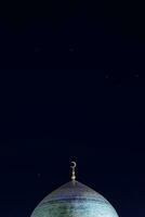 The golden crescent on the dome of the Mosque. Waxing moon - a symbol of Islam at the top of the temple at night sky with stars. Free space. For Ramadan and Eid background photo