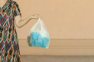 Plastic pollution. Female collected plastic bottles and holding recycling bin. Free space photo