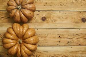 Two big pumpkins on wooden desk. Fall background photo