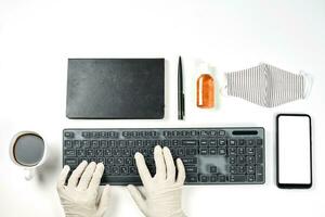 A person in medical gloves working safely in the office during the coronavirus pandemic photo