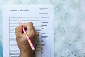 Hand filling Schengen Visa Application Form photo