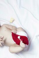 9 9 mes bebé chico con Papa Noel claus sombrero. Navidad Mañana. pequeño niño jugando. foto