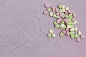 Marshmallows on pink background. Colorful marshmallow sweets with copy space photo