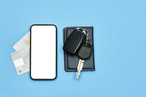 Car keys, mobile phone and credit cards on blue photo