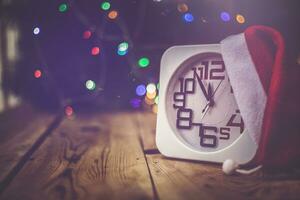 Christmas holiday eve. New year decor with bokeh lights. Magic Winter. Clock at midnight. Greeting new 2020 Year. Clock with blurry magic lights. photo