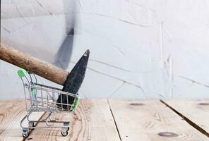 Unhappy customer. Shopping cart and hammer photo