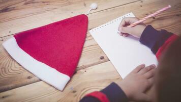 Little boy writing to Santa Claus. A kid writes a letter to Santa Claus. Child thinking, dreaming about Christmas wish photo