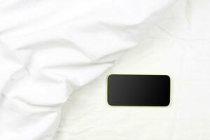 Black smartphone on the bed photo