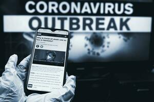 Doctor checking news on smartphone about COVID-19 situation in Germany photo