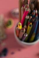 Stack of colorful pencils and shaves around it photo