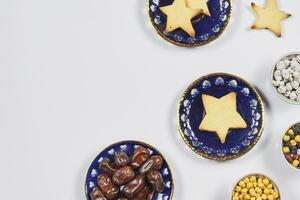 Iftar foods on white table. Traditional middle-eastern lunch with cookies and dry date fruits photo