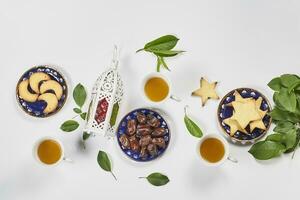 Iftar foods on white table. Traditional middle-eastern lunch with cookies and sweets photo