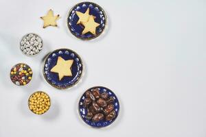 Iftar foods on white table. Traditional middle-eastern lunch with cookies and dry date fruits photo