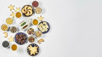 Iftar foods on white table. Traditional middle-eastern lunch with cookies and sweets photo