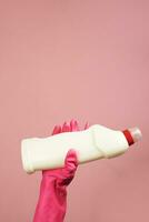 Female hand in rubber gloves holding cleaning supply or disinfectant bottle photo