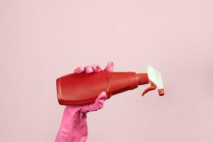 Female hand in rubber gloves holding disinfectant spray photo