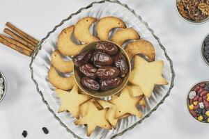 Iftar foods on white table. Traditional middle-eastern lunch with cookies and dry date fruits photo